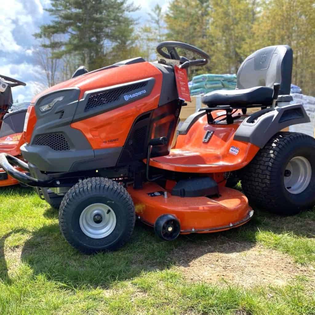 On the grass is the Husqvarna Fast Continuously Varilable Transmission Pedal Tractor Mower