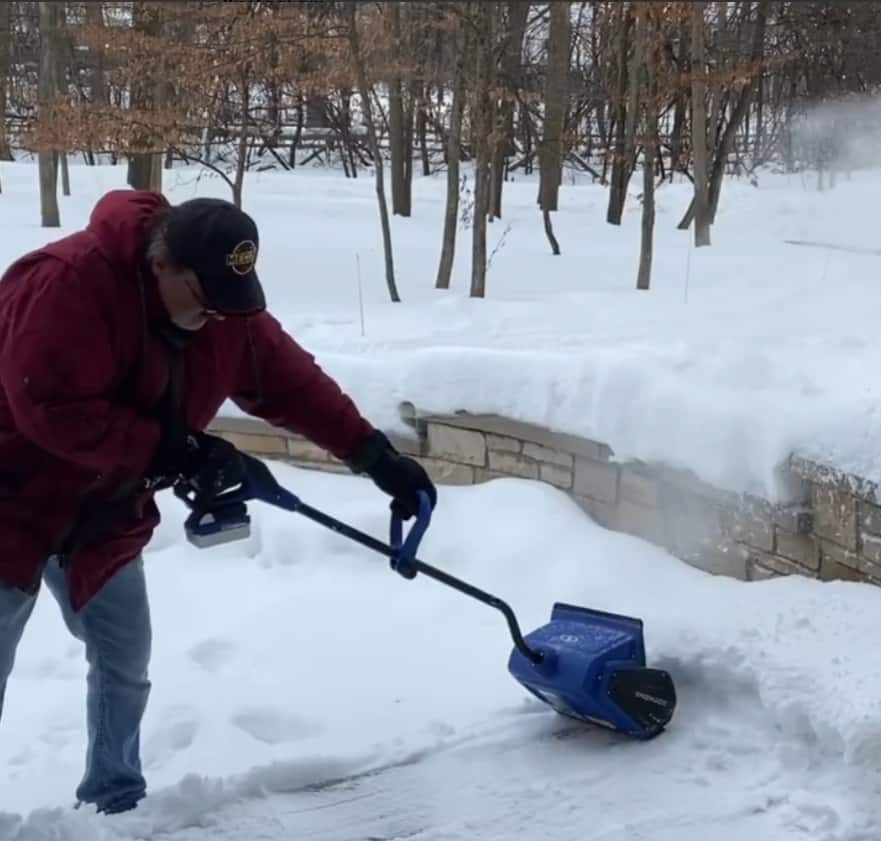 A man works with the Snow Joe Snow Shovel
