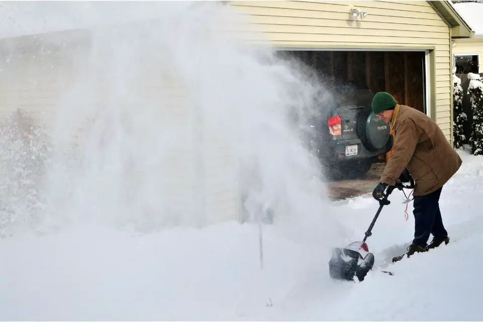 Man-shovelling-snow-with-electric-snow-shovel