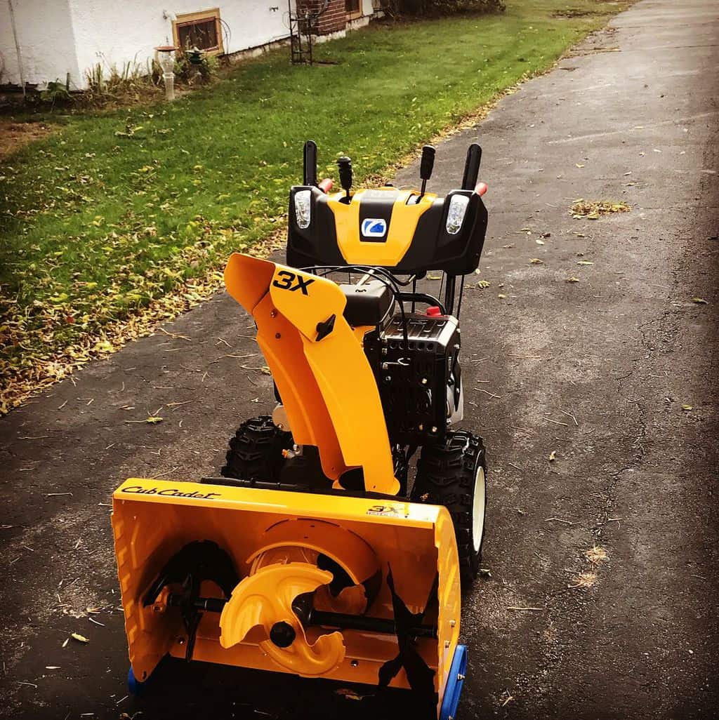 There is a Cub Cadet 3x Hydrostatic 3-Stage Snow Blower on asphalt