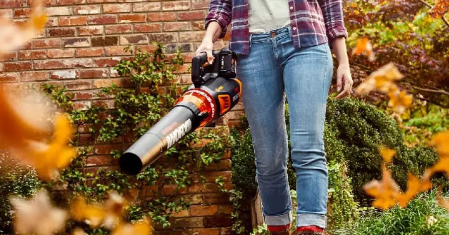 Woman using a leaf blower in the garden