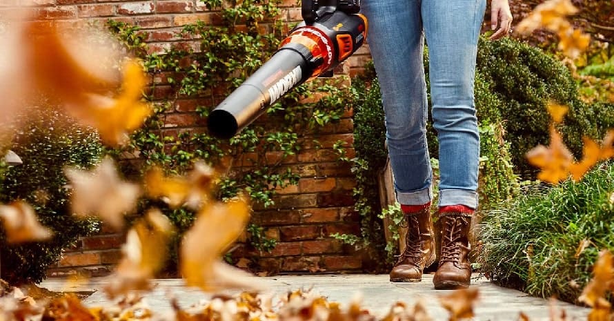 Woman using a leaf blower in the garden