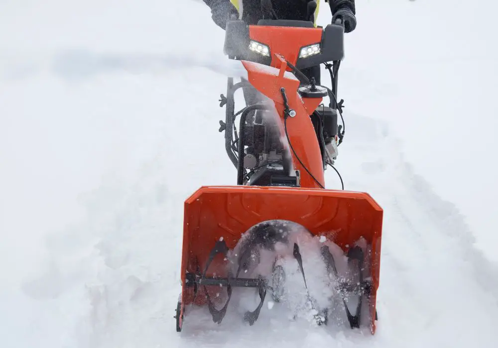 Man works with snow blower