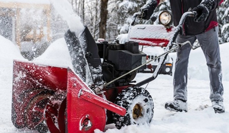 Man Uses Snow Blower on Driveway